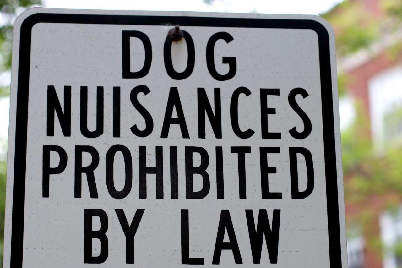 Sign reading-- Dog nuisances prohibited by law.