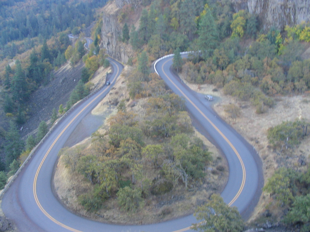 The Historic Columbia River Highway loops around beneath the Rowena Crest Viewpoint. Byway travelers descend from the viewpoint to the loops below.