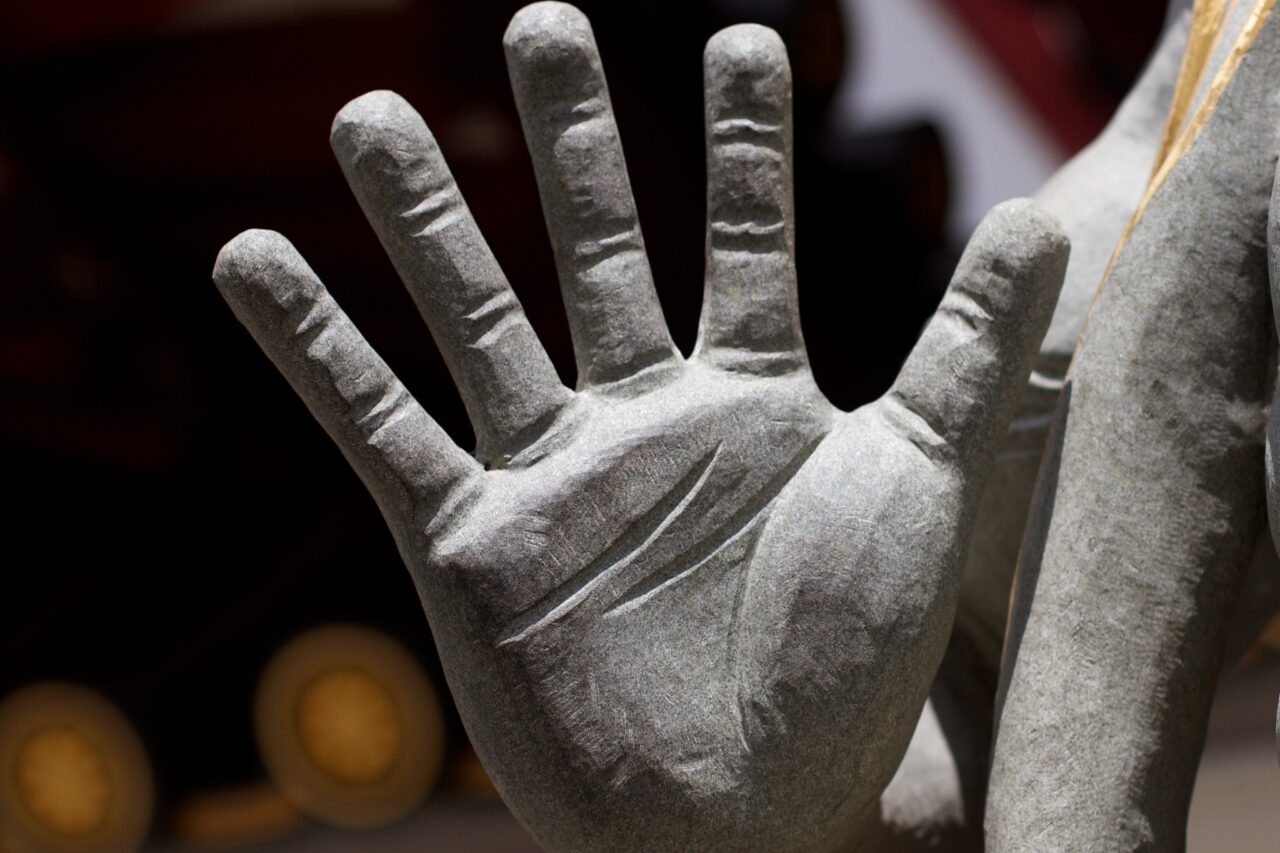 Detail of a statue's hand, with fingers widely spread