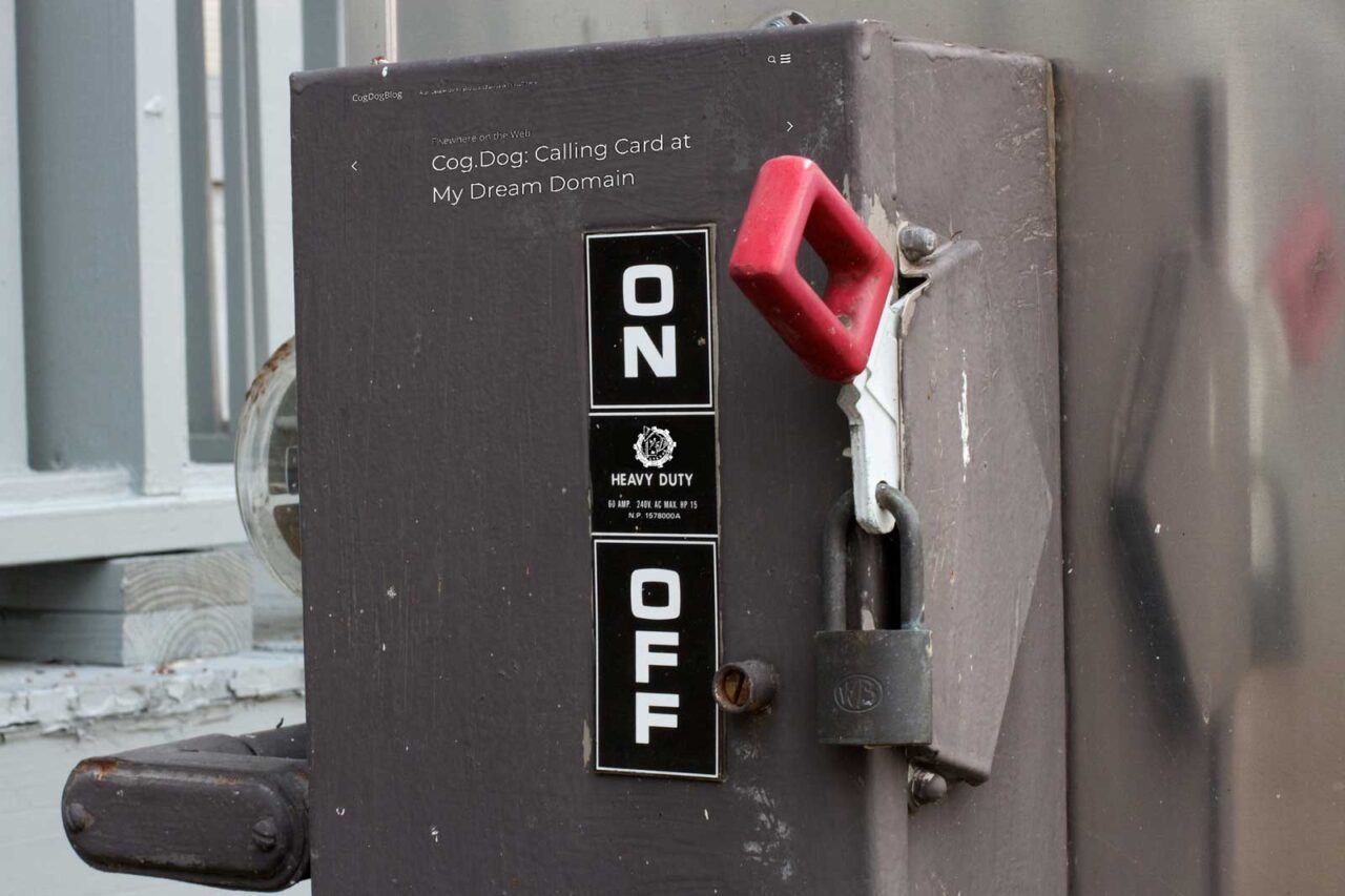 Large electric utility switch in the On position, at thew top of the box is superimposed the header ofcogdogbllog,com