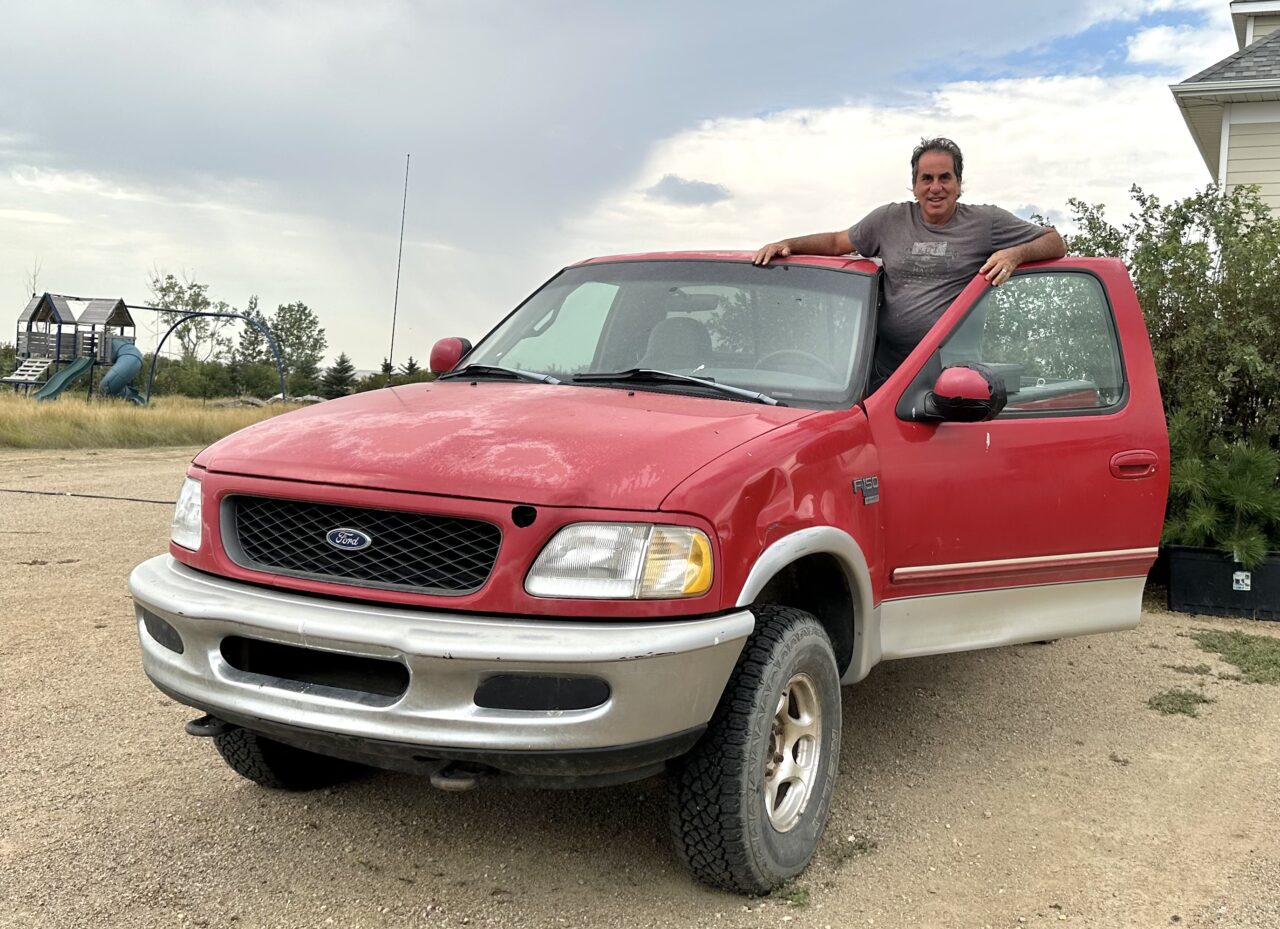Man standing in entracce to red truck