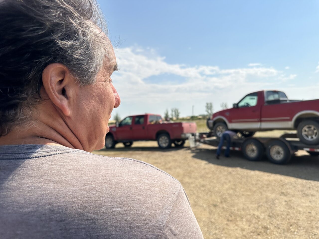 Man watching as red truck is pulled away.